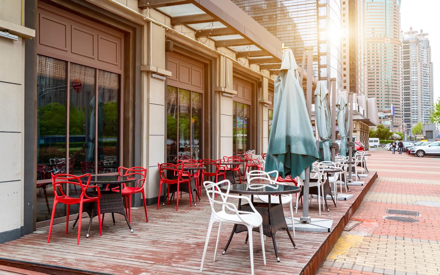 A sidewalk with tables and chairs