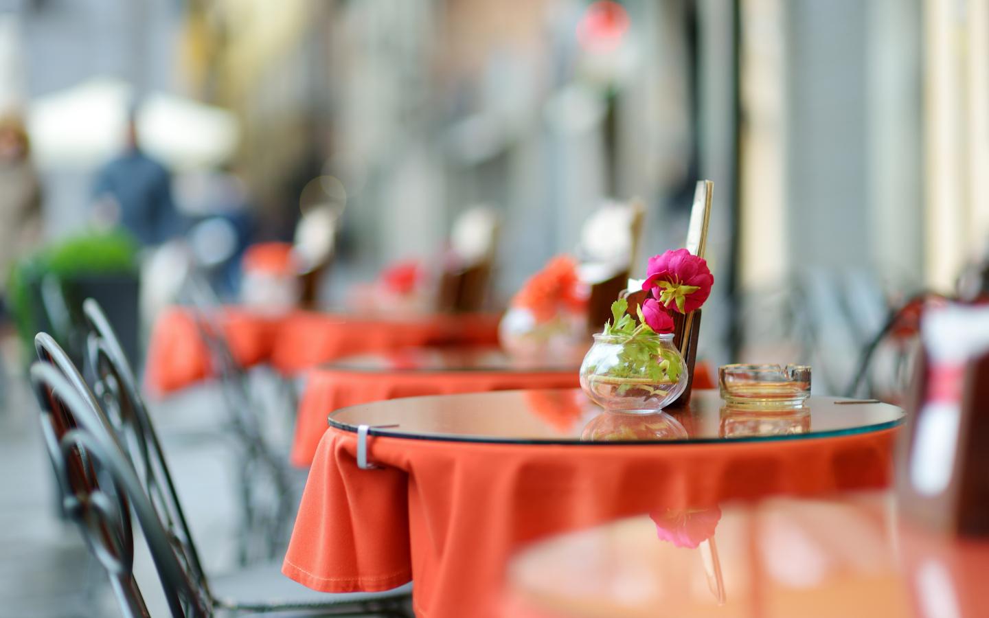 A table with chairs and tables with red tablecloths