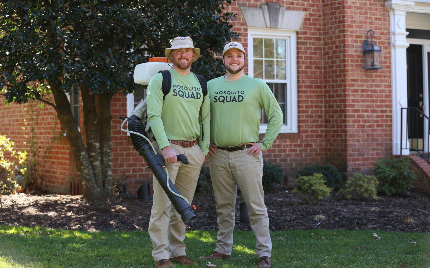 mosquito squad men worker smiling outside house