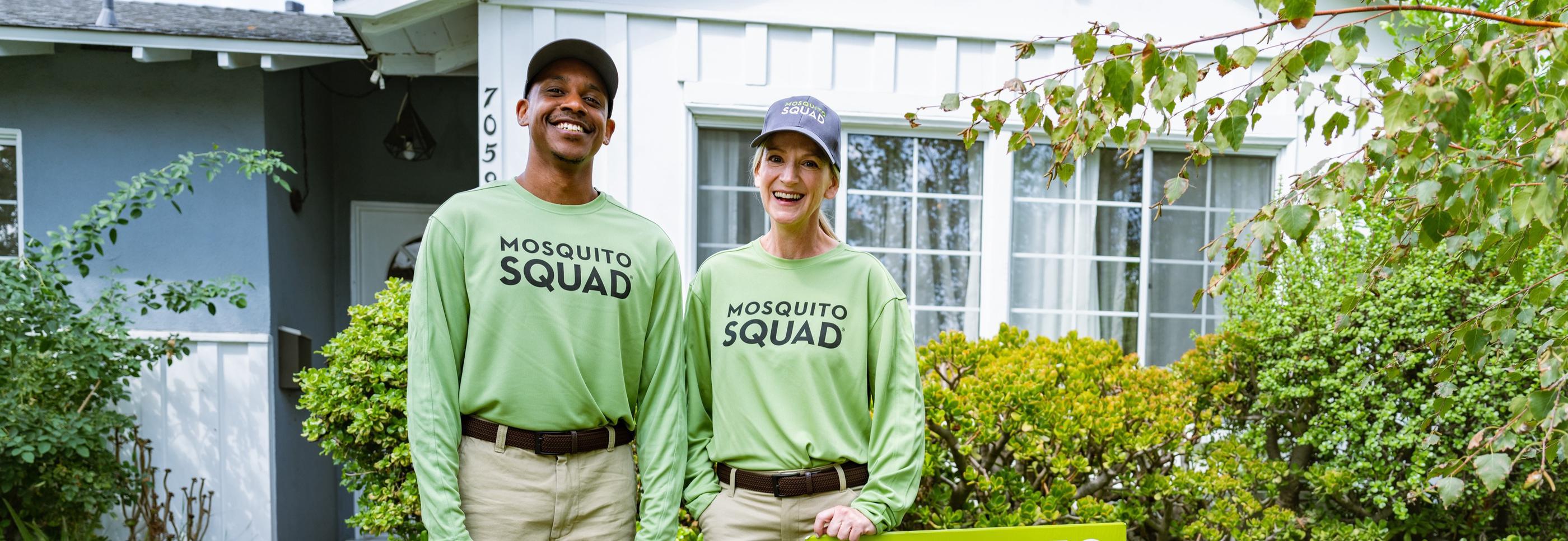 Two Mosquito Squad employees standing outside of a customer's house.