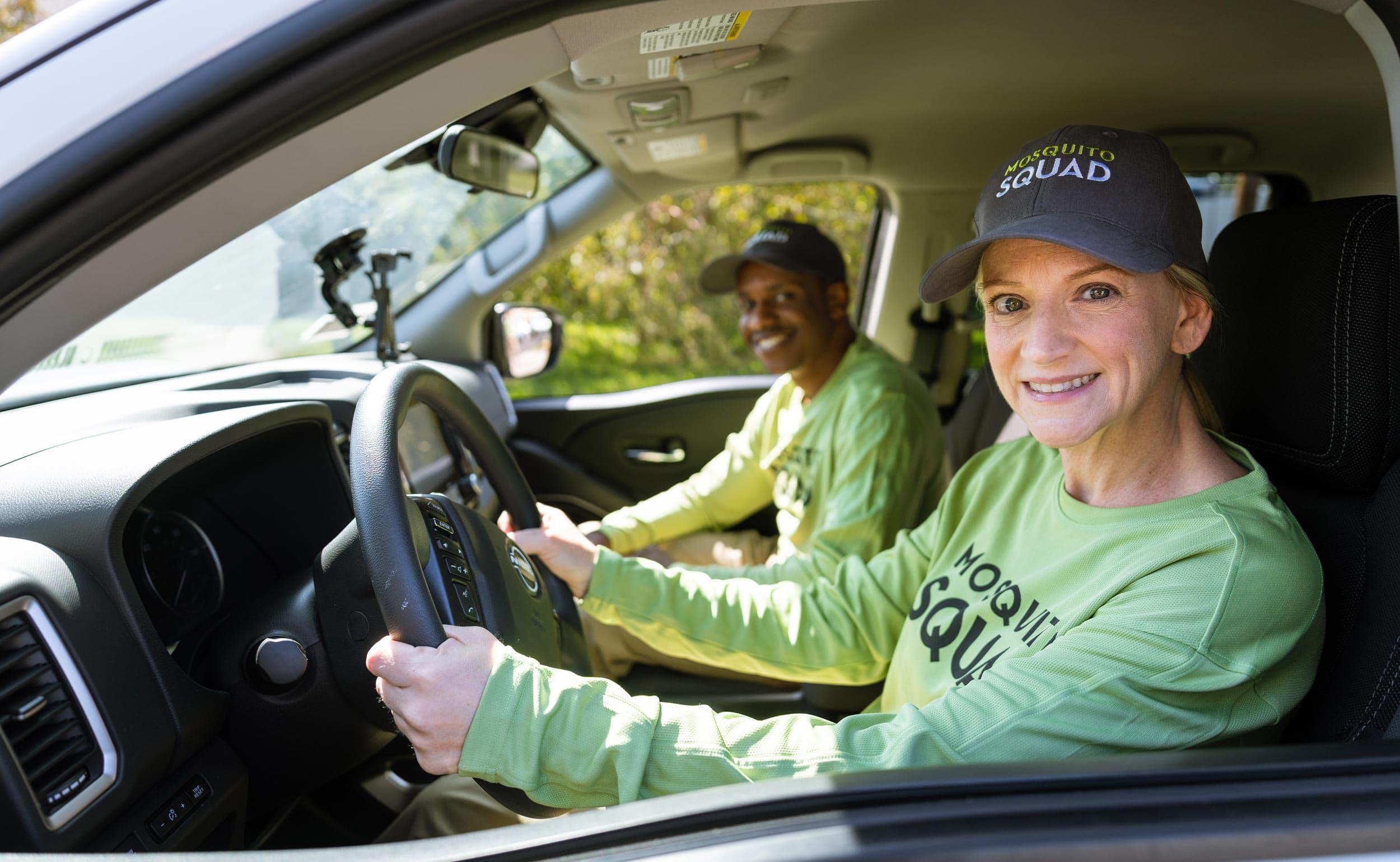 Two Mosquito Squad employees in a car.