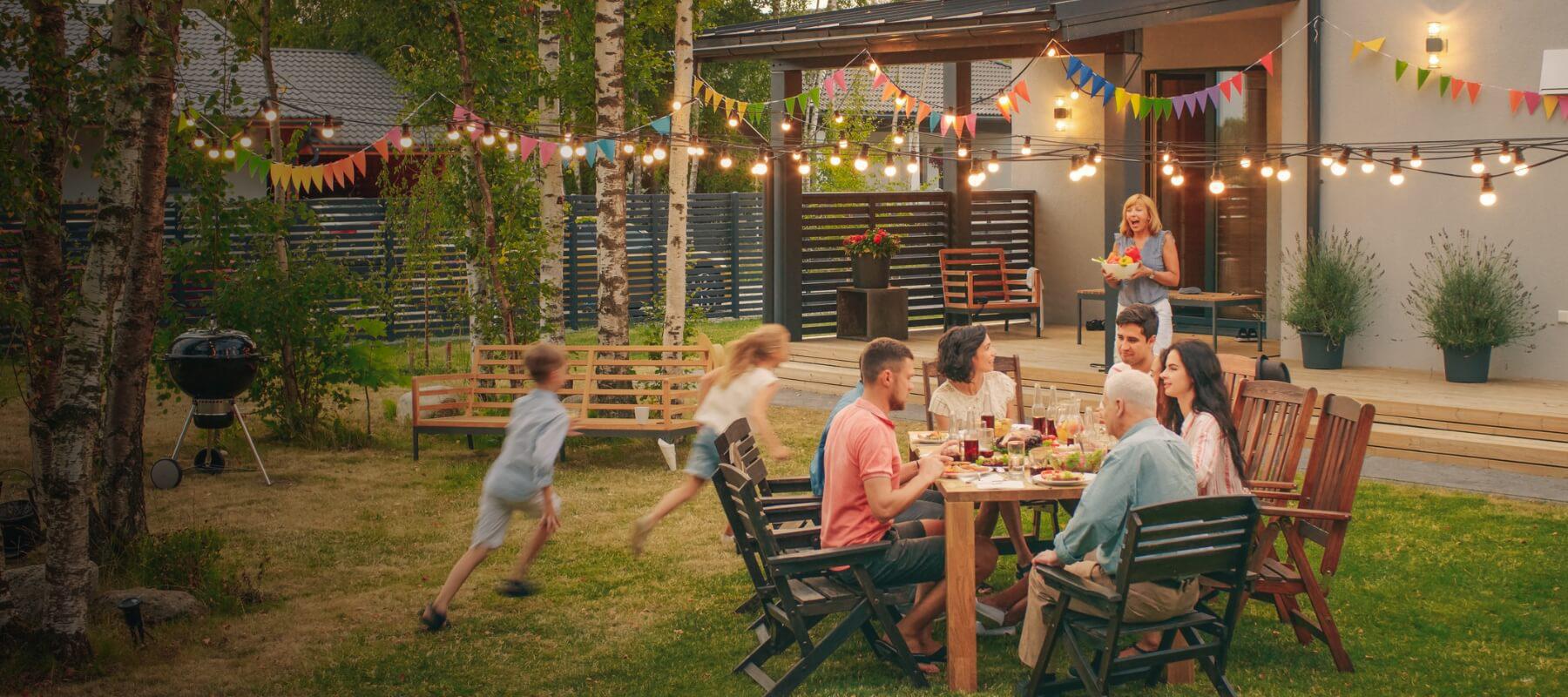 family sitting on log near fire pit