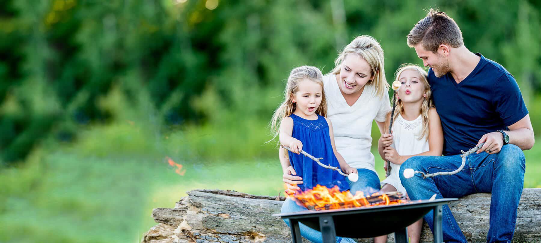 A family roasting marshmallows outside 