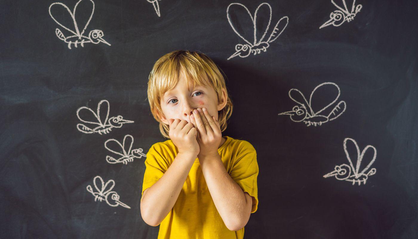 A child covering his mouth with his handsDescription automatically generated